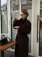 Жінка в коричневому максі пальто Muse з чашкою кави, вид спереду