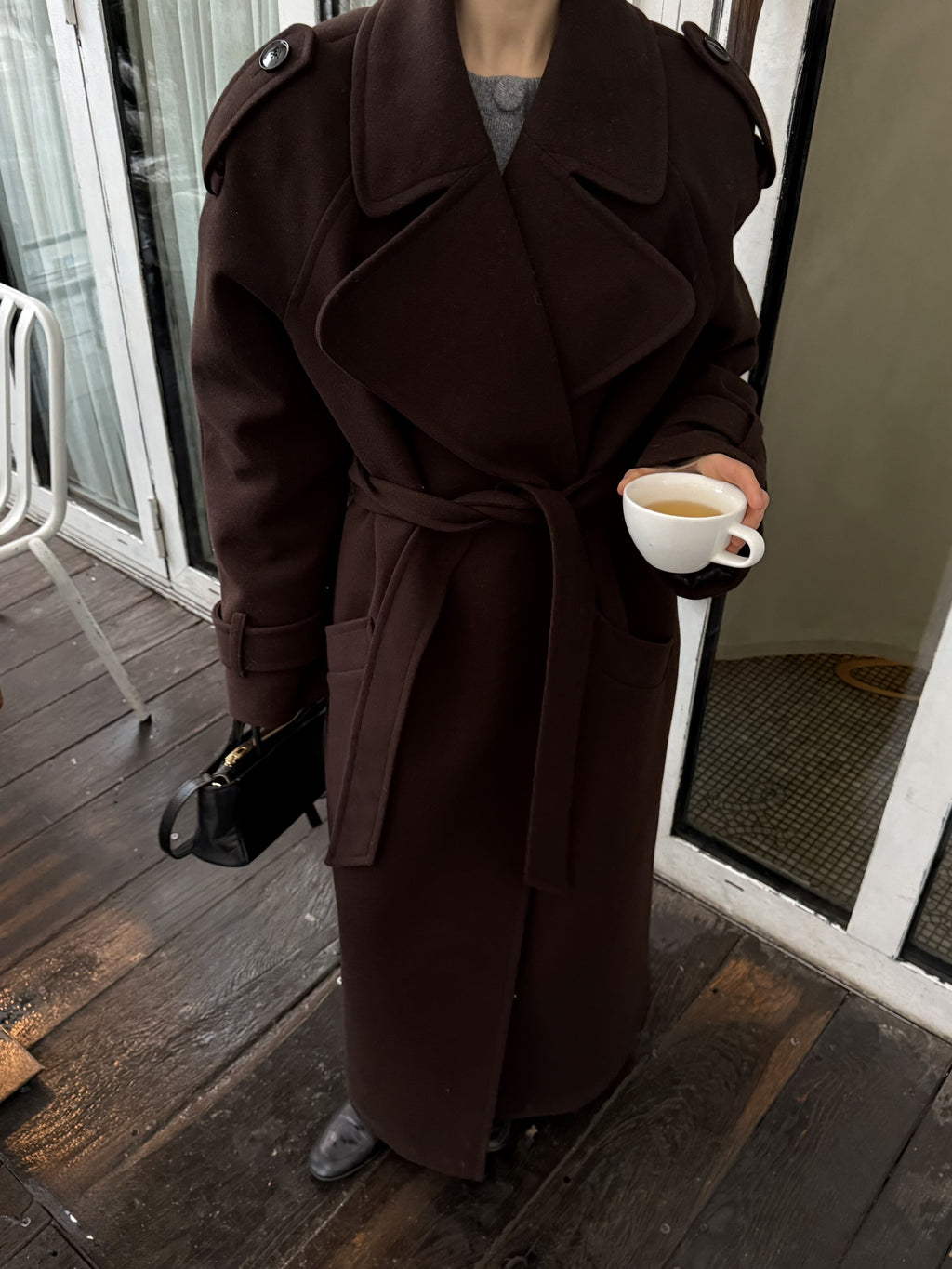 Жінка в коричневому максі пальто Muse з чашкою кави, вид зверху