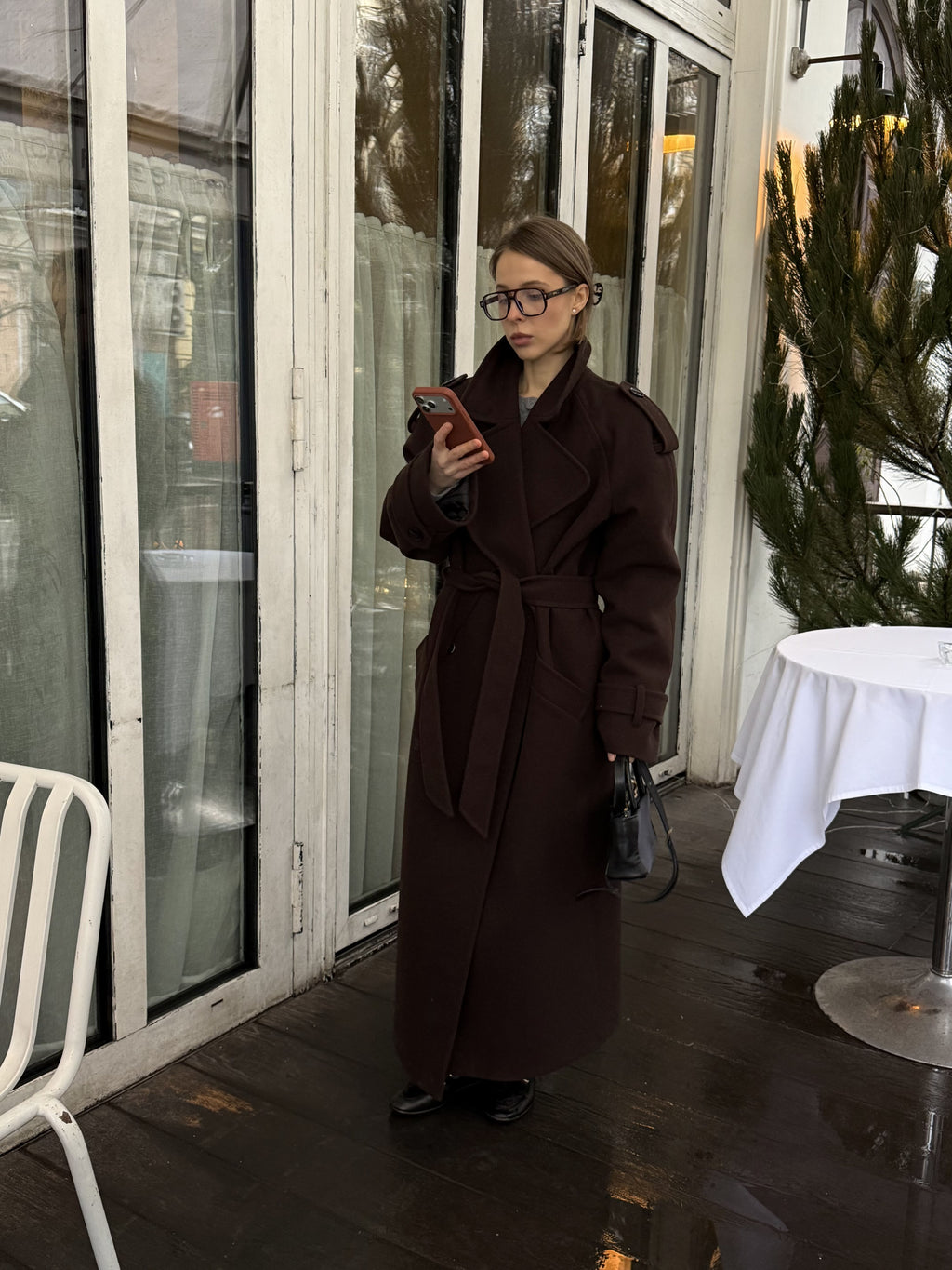 Жінка в коричневому максі пальто Muse з телефоном, вид спереду